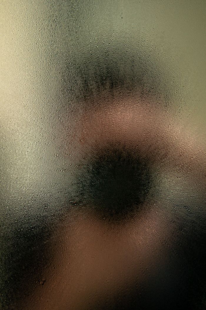 Abstract image showing a blurred reflection on a moist glass surface.